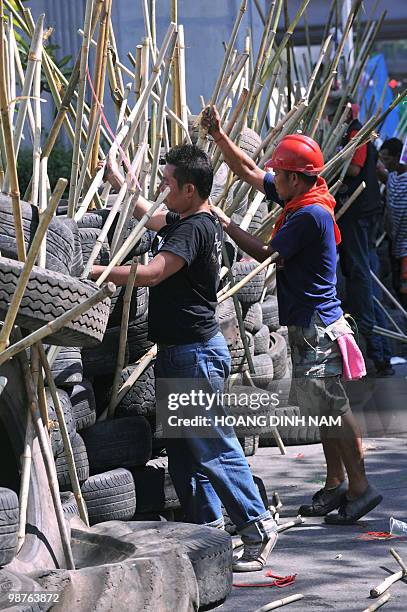 Thai Red-Shirt anti-government protesters place used truck tyres and sharpened bamboo sticks to build up a new barricade after they accepted to move...