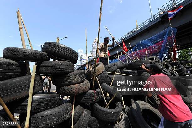 Thai Red-Shirt anti-government protesters place used truck tyres to build up a new barricade after they accepted to move back their main barricade at...