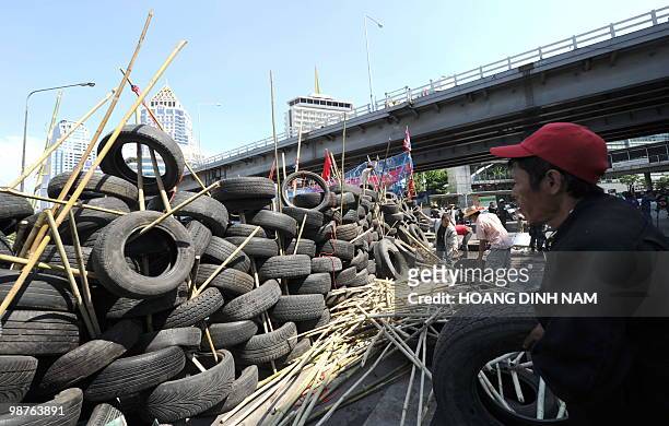 Thai Red-Shirt anti-government protesters place used truck tyres and sharpened bamboo sticks to build up a new barricade after they accepted to move...