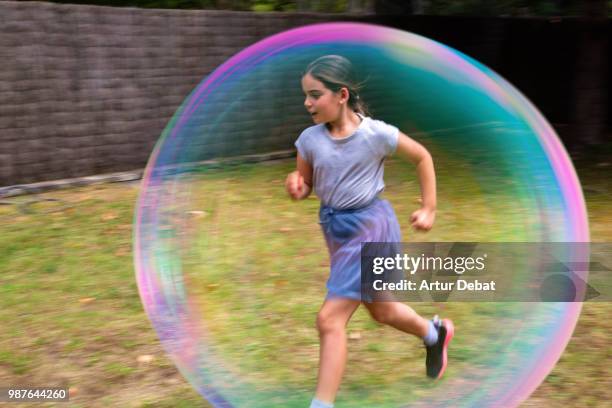 bubble kid running in backyard. - garder photos et images de collection