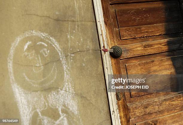 Chalk drawing by a victim is seen next to a sealed door at the crime scene where an Egyptian suspect killed an elderly couple and their two...