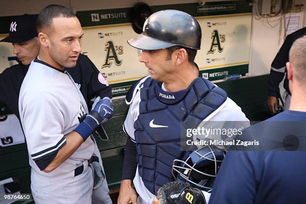 Derek Jeter and Jorge Posada of the New York Yankees standing in the dugout prior to the game against the Oakland Athletics at the Oakland Coliseum...