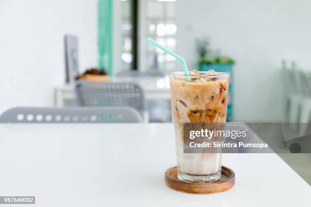 a glass of ice coffee on the white table in coffee shop. - iced coffee foto e immagini stock