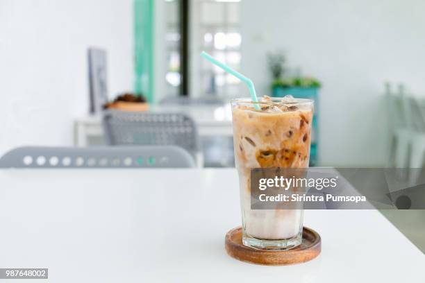 a glass of ice coffee on the white table in coffee shop. - iced coffee stock pictures, royalty-free photos & images