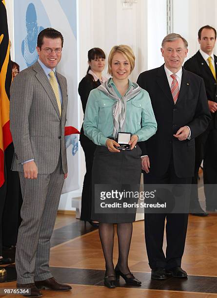 German President Horst Koehler and German Defense Minister Karl-Theodor zu Guttenberg pose with the German biathlete Magdalena Neuner at the...