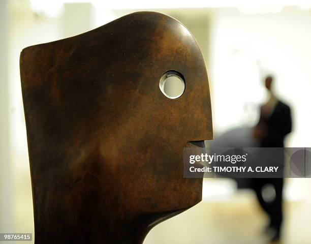 Person walks past a statue called "Head" by Henry Moore during a press preview April 30, 2010 at Sotheby's New York for their spring sales of...