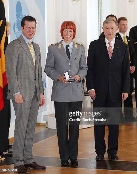German President Horst Koehler and German Defense Minister Karl-Theodor zu Guttenberg pose withGerman biathlete Kati Wilhelm at the Silbernes...