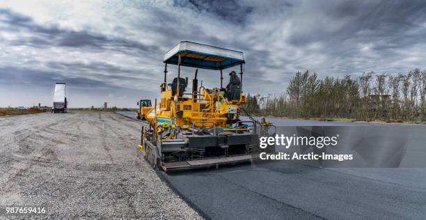 paving a new road, iceland - asphalt paver foto e immagini stock