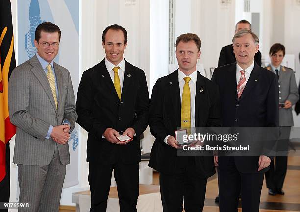 German President Horst Koehler and German Defense Minister Karl-Theodor zu Guttenberg pose with German biathletes Wilhelm Brem and Florian Grimm at...