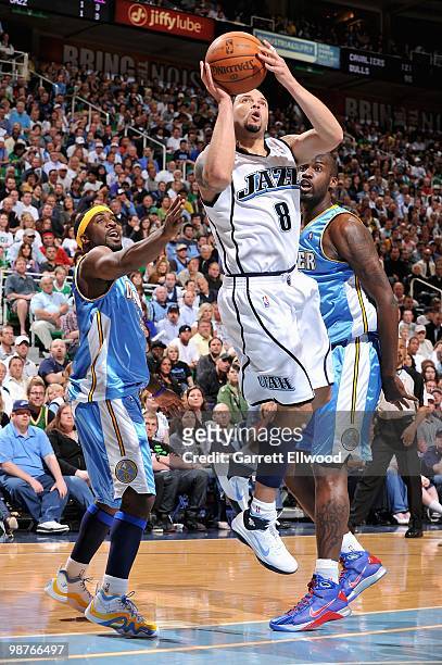 Deron Williams of the Utah Jazz goes up for a shot over Ty Lawson and Johan Petro of the Denver Nuggets in Game Four of the Western Conference...