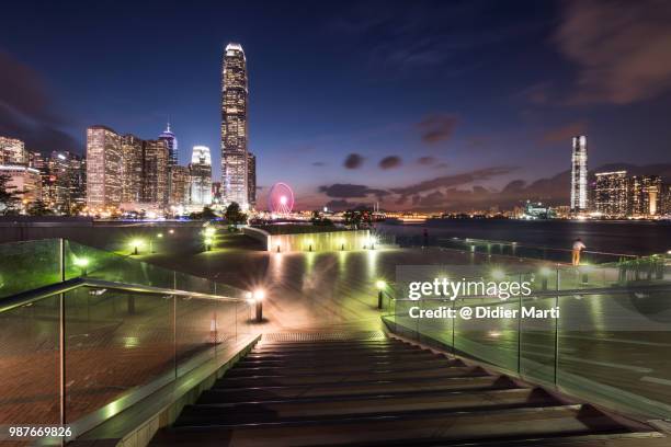 twilight over the skyscrapers of the central business district in hong kong island with kowloon skyline across the victoria harbor in the background - didier marti stock pictures, royalty-free photos & images