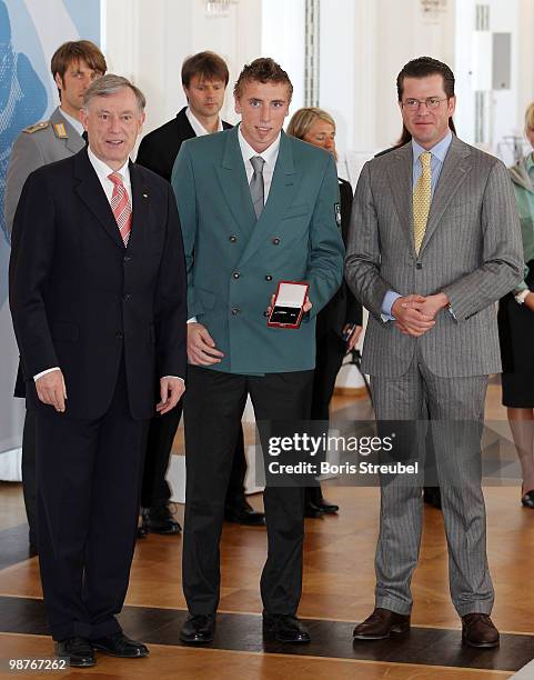 German President Horst Koehler and German Defense Minister Karl-Theodor zu Guttenberg pose with the cross country skier Tim Tscharnke at the...