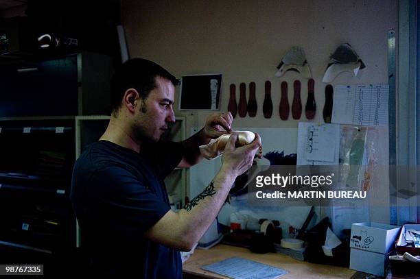 An employee adjusts a ballet shoe at the Repetto workshop on March 25, 2010 in Saint-Medard d'Excideuil, central France. Created in 1947 by Rose...