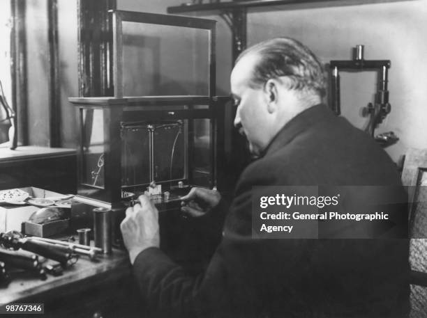 Gunsmith and ballistics expert Robert Churchill using a micro-balance to help compile a ballistic report for Scotland Yard in the case of the murder...