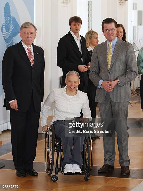 German President Horst Koehler and German Defense Minister Karl-Theodor zu Guttenberg pose with the cross country skier Andrea Eskau at the Silbernes...