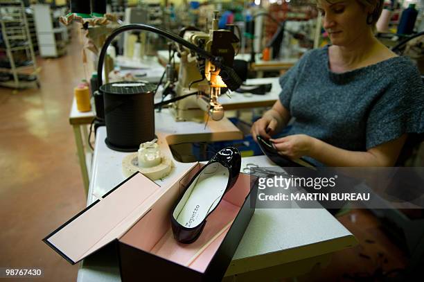 Woman adjusts a ballet shoe at the Repetto workshop on March 25, 2010 in Saint-Medard d'Excideuil, central France. Created in 1947 by Rose Repetto,...