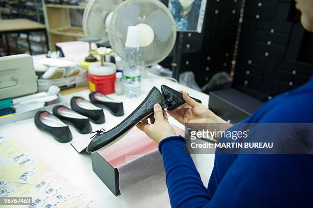 Woman adjusts a ballet shoe at the Repetto workshop on March 25, 2010 in Saint-Medard d'Excideuil, central France. Created in 1947 by Rose Repetto,...