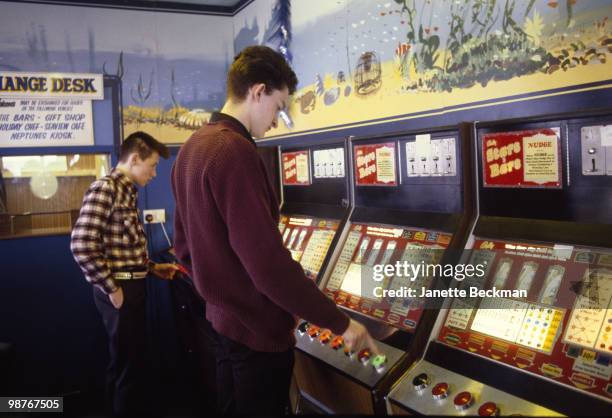 Rockabilly fans play slot machines in Neptune's Palace, which was hosting an annual music festival, Caister-on-Sea, Norfolk, England, November 1981.