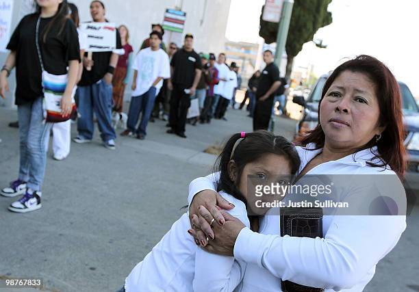Woman embraces her child as they watch the group "Youth United For Justice" protest Arizona's new immigration law April 30, 2010 in Oakland,...