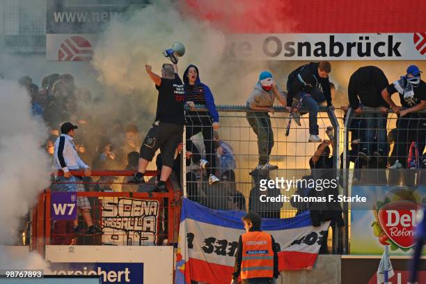 Supporters of Kiel fire smoke bombs during the Third League match between VfL Osnabrueck and Holstein Kiel at the Osnatel Arena on April 30, 2010 in...