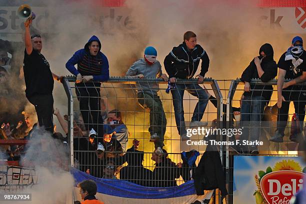 Supporters of Kiel fire smoke bombs during the Third League match between VfL Osnabrueck and Holstein Kiel at the Osnatel Arena on April 30, 2010 in...