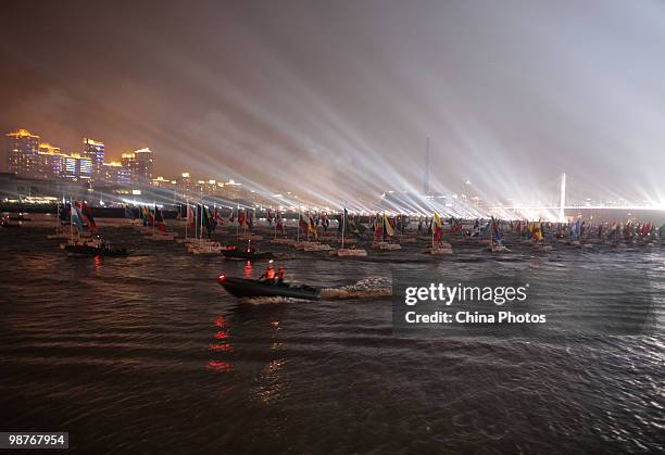 Boats flying the flags of various nations and organizations sail down the Huangpu River during the opening ceremony of the 2010 World Expo on April...