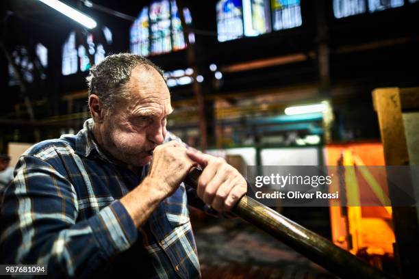 glass blower using blowpipe in a glass factory - glass factory stock-fotos und bilder