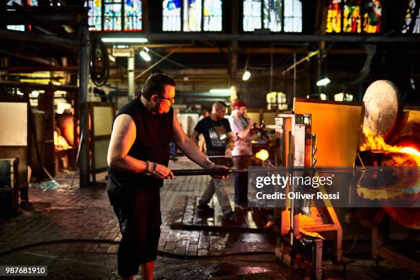 man working at furnace in a glass factory - blowgun stock pictures, royalty-free photos & images