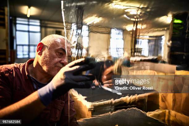 man in a glass factory examining glass pane - glass factory stock-fotos und bilder