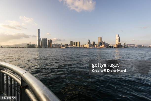 a view of the tsim sha tsui skyline in kowloon from across the victoria harbor in the late afternoon in hong kong - didier marti stock pictures, royalty-free photos & images