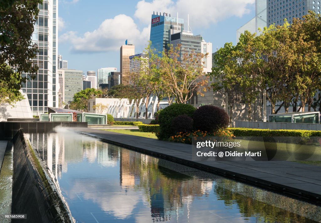 Reflection of the skyscrapers of the Central business district in Hong Kong island in the water of a pond