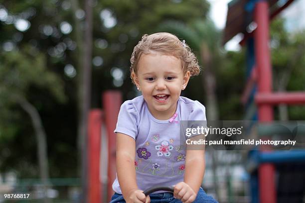 young girl having fun at the playground - paul mansfield photography stock pictures, royalty-free photos & images