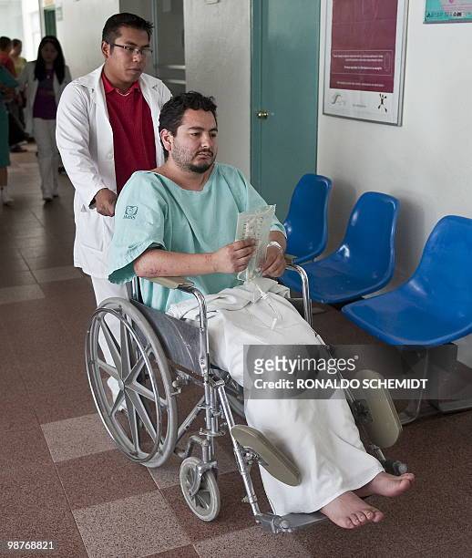 Mexican photographer David Cilia's wheelchair is pushed by a male nurse to a room where a press conference will be held at the hospital of Santiago...