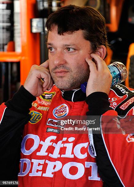 Tony Stewart, driver of the Office Depot/Old Spice Chevrolet covers his ears in the garage during practice for the CROWN ROYAL Presents the Heath...