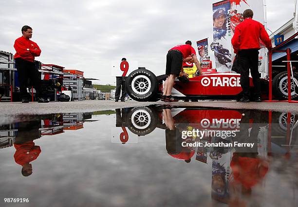 Mechanics push Scott Dixon's Target Chip Ganassi Racing Honda Dallara into the garage as rain delays practice for the Indy Car Series Road Runner...