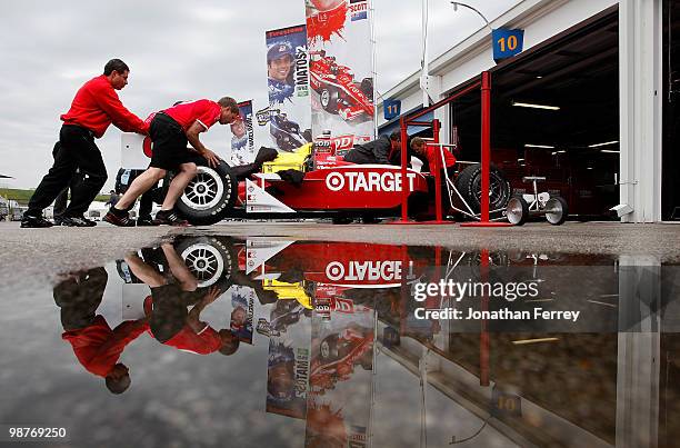 Mechanics push Scott Dixon's Target Chip Ganassi Racing Honda Dallara into the garage as rain delays practice for the Indy Car Series Road Runner...