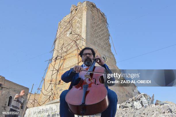 Famed Iraqi maestro and cello player Karim Wasfi performs in front of the Al-Hadba minaret at the the Great Mosque of al-Nuri in Mosul's war-ravaged...