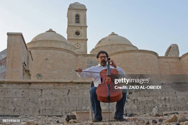 Famed Iraqi maestro and cello player Karim Wasfi performs in front of the Roman Catholic Church of Our Lady of the Hour in Mosul's war-ravaged Old...