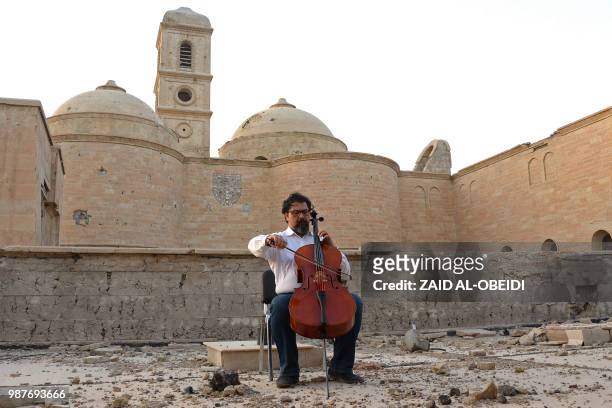 Famed Iraqi maestro and cello player Karim Wasfi performs in front of the Roman Catholic Church of Our Lady of the Hour in Mosul's war-ravaged Old...