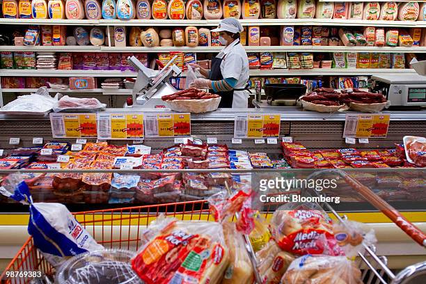 An employee cuts meats at a Chedraui grocery store in Mexico City, Mexico, on Friday, April 30, 2010. Mexican retailer Grupo Comercial Chedraui SAB...