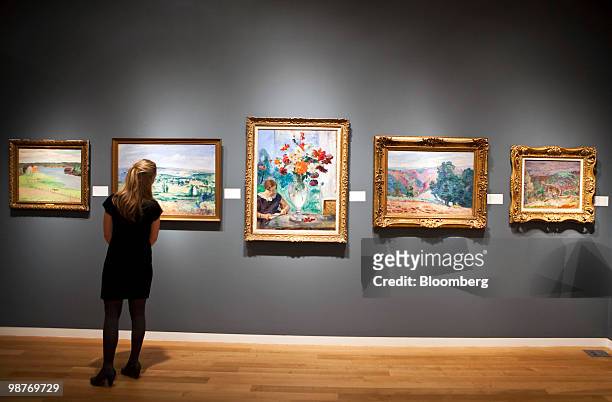 Woman looks at impressionist paintings on display during a press preview at Sotheby's in New York, U.S., on Friday, April 30, 2010. Sotheby's will...