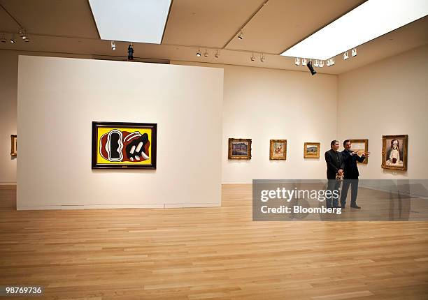 Members of media look at impressionist and modern art paintings on display during a press preview at Sotheby's in New York, U.S., on Friday, April...