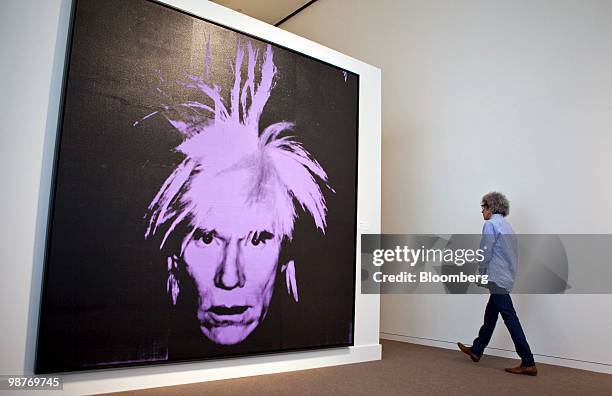 Man walks by "Self Portrait" by Andy Warhol during a press preview at Sotheby's in New York, U.S., on Friday, April 30, 2010. The piece is estimated...