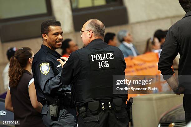 Members of the Immigration and Customs Enforcement agency keep watch over demonstrators protesting against a new Arizona law on April 30, 2010...