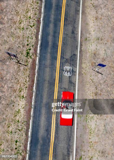 red car driving down famous road. - route 66 stock pictures, royalty-free photos & images