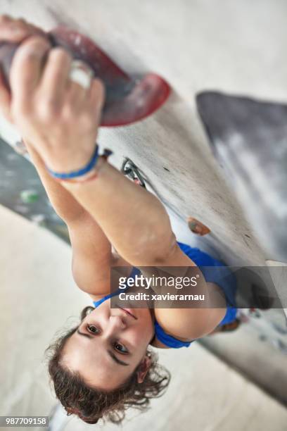 überzeugt junge weibliche kletterwand im fitness-studio - nur erwachsene stock-fotos und bilder