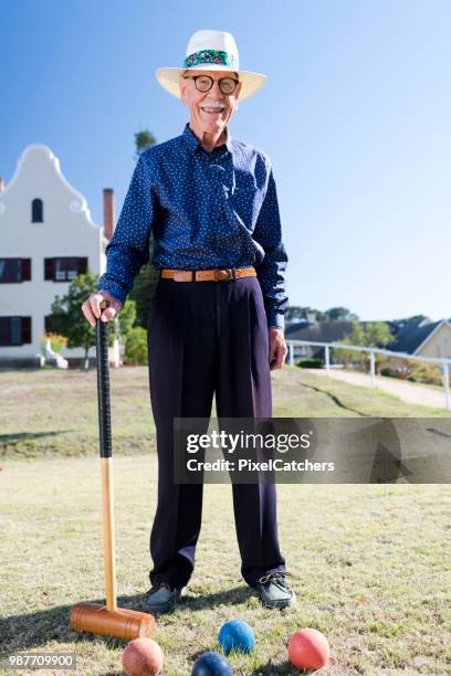 retrato de un hombre mayor en una pista de croquet al aire libre bajo el sol - croquet fotografías e imágenes de stock