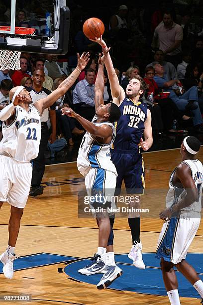 Josh McRoberts of the Indiana Pacers goes for the layup over James Singleton and Cartier Martin of the Washington Wizards during the game at the...