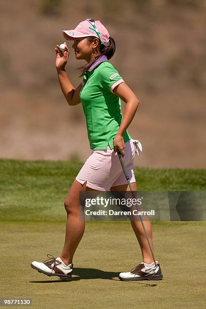 Ai Miyazato of Japan raises her ball to acknowledge the crowd after a birdie on the ninth hole during the second round of the Tres Marias...