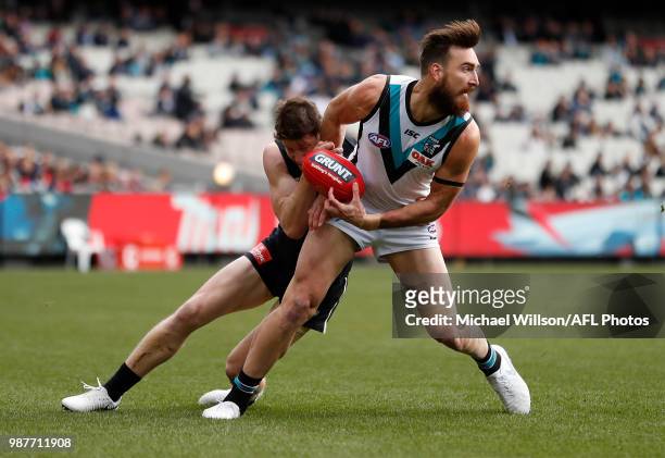 Charlie Dixon of the Power is tackled by Sam Rowe of the Blues during the 2018 AFL round15 match between the Carlton Blues and the Port Adelaide...